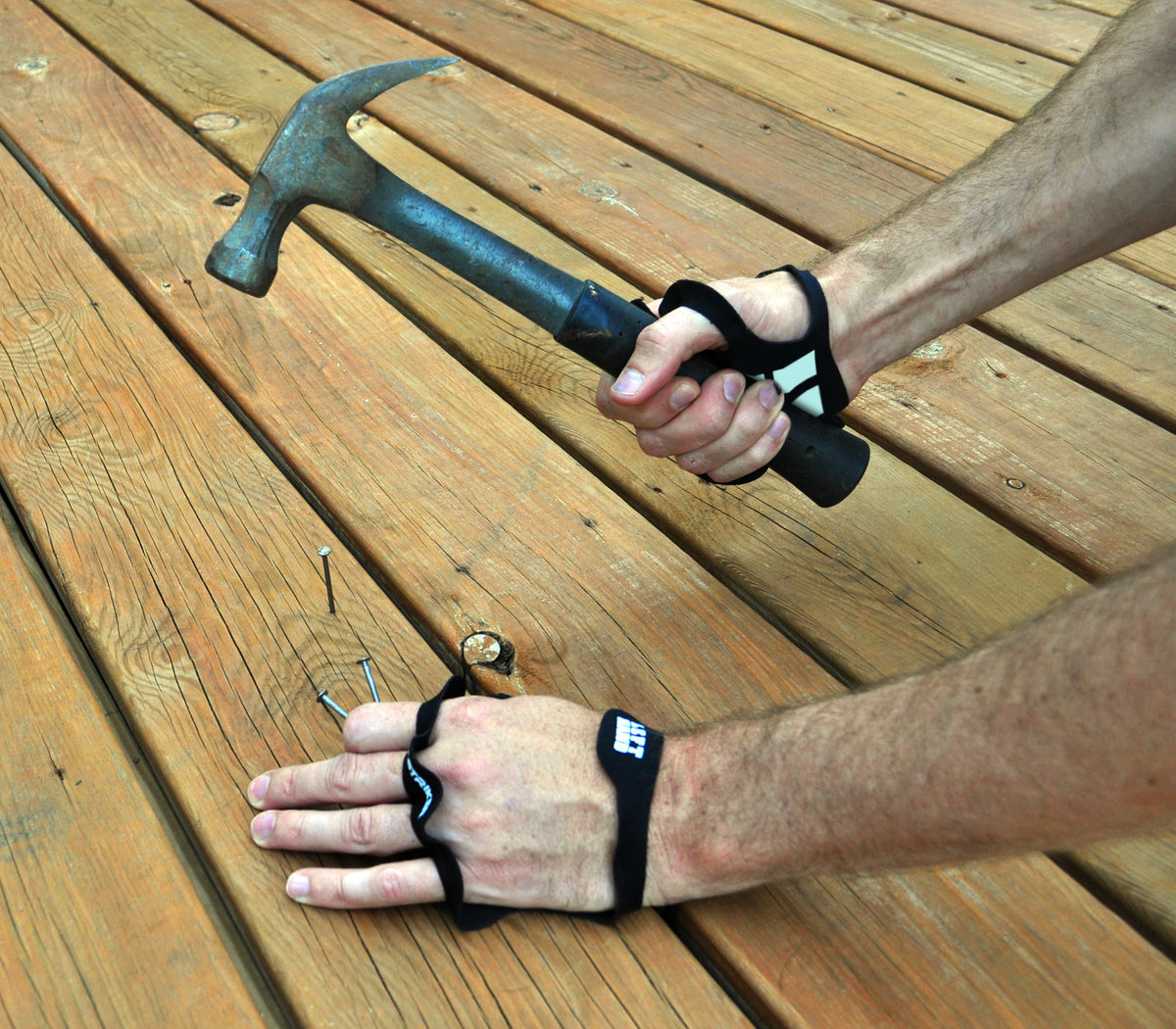 Palm Protectors worn while swinging a hammer and holding nails on a wood deck